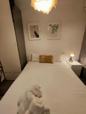 a bedroom with a white bed with a stuffed animal on it at Pequeño Alojamiento con Mini Piscina - NO climatizada in Valencia