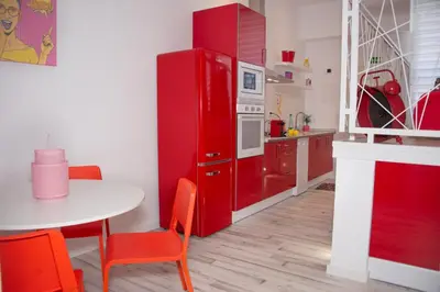 a red refrigerator in a kitchen with a table at Soraya's Place - Chopín 3 in Valencia