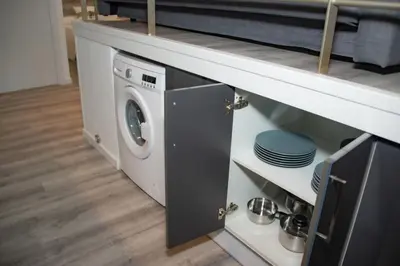 a washer and dryer sitting under a kitchen counter at Soraya's Place - Chopín 4 in Valencia