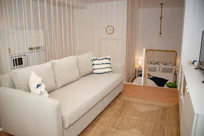 a living room with a white couch and a bedroom at Soraya's Place - Chopín 5 in Valencia