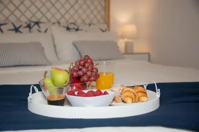 a tray of fruit and pastries on a bed at Soraya's Place - Chopín 5 in Valencia