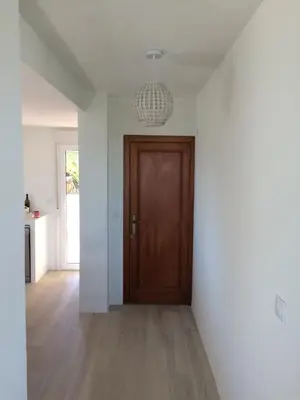 a hallway with a wooden door and a chandelier at Beach House Villa Roca in Cullera