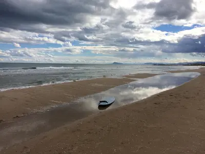 a boat is sitting on the sand on the beach at Beach House Villa Roca in Cullera