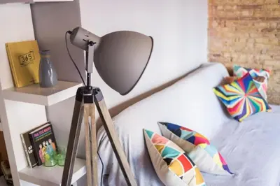 a lamp sitting next to a bed in a bedroom at Precioso atico en pleno centro de Valencia in Valencia