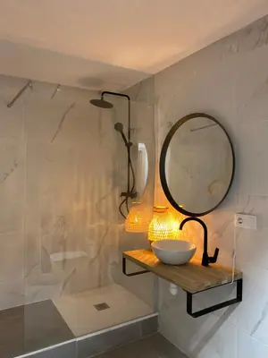 a bathroom with a sink and a mirror on a shelf at Shanti Rooms in Valencia