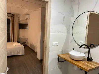 a bathroom with a sink and a mirror on a wall at Shanti Rooms in Valencia