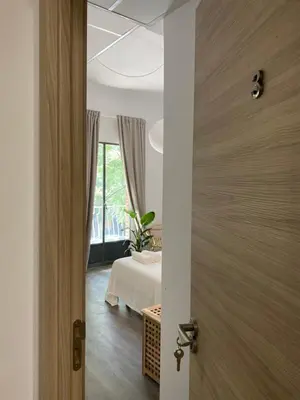 an open door to a room with a bed and a window at Shanti Rooms in Valencia