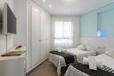 a bedroom with two beds and a television in it at ApartUP Patacona Essence in Valencia
