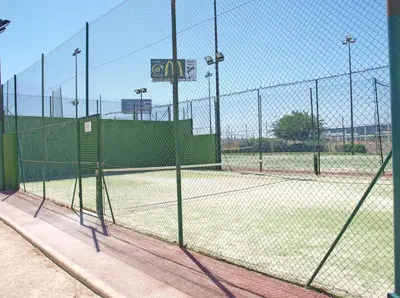 an empty tennis court behind a fence at ApartUP Patacona Essence in Valencia