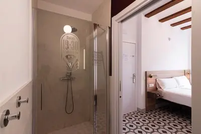 a shower with a glass door in a bedroom at Hotel 19-30 Valencia in Valencia