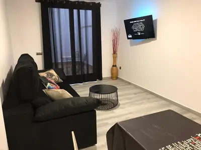 a living room with a black couch and a tv at Star Anna in Anna