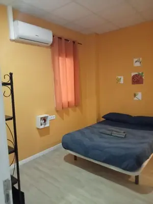 a bedroom with a bed with blue sheets and a window at Colors Rooms in Valencia