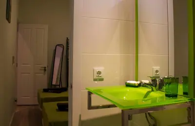 a bathroom with a green sink and a mirror at Colors Rooms in Valencia