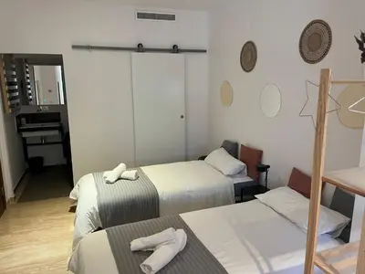 a room with two beds and a table with towels at Pensión Les Eres in Puebla de Vallbona