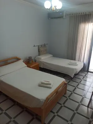 two beds in a room with a tiled floor at Casa MarTa in Chella
