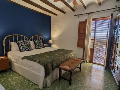 a bedroom with a bed and a chair and a window at Ca'n Josep in Segorbe