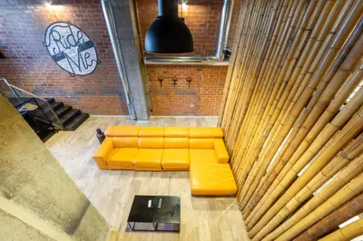 a yellow couch in a room with a brick wall at ART LOFTS Valencia by Benisur in Valencia