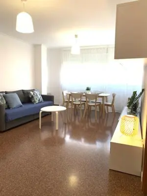 a living room with a blue couch and a table at UIM Mediterraneo Diagonal 17 Wifi in Puerto de Sagunto
