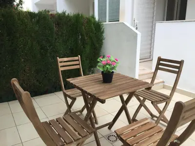a wooden table with two chairs and a potted plant at Ideal house at the Beach in Sagunto(Valencia) in Sagunto