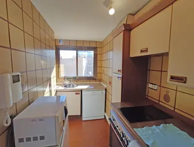a small kitchen with a sink and a microwave at Sunny apartment with fantastic terrace views! in Valencia