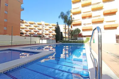 a swimming pool in front of a building at Global Vacacional, Apartamento en la playa de Canet d'en Berenguer in Canet de Berenguer