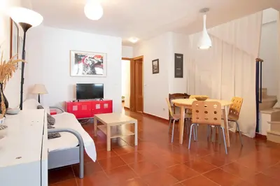a living room with a table and a couch at Global Vacacional, Apartamento con piscina en playa Corinto in Sagunto