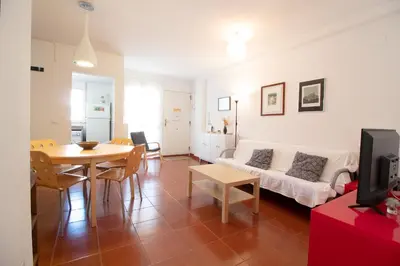 a living room with a couch and a table at Global Vacacional, Apartamento con piscina en playa Corinto in Sagunto