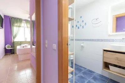 a bathroom with purple walls and a sink and a shower at Global Vacacional, Estudio para parejas en la playa del Puerto de Sagunto in Puerto de Sagunto