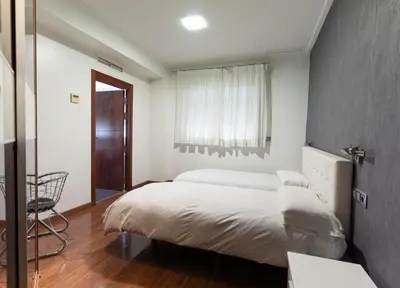 a bedroom with a large bed and a window at Hotel Lluna in Alzira