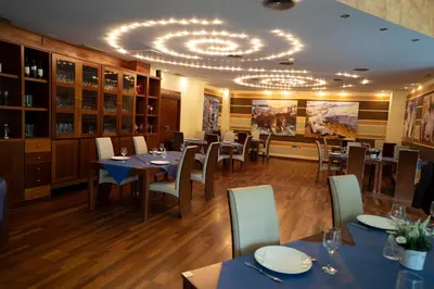 a restaurant with tables and chairs and a chandelier at Hotel Lluna in Alzira