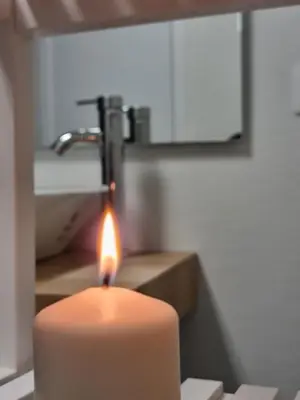 a candle in a bathroom with a sink at Alojamientos Segóbriga Rural ( Mandil) in Segorbe