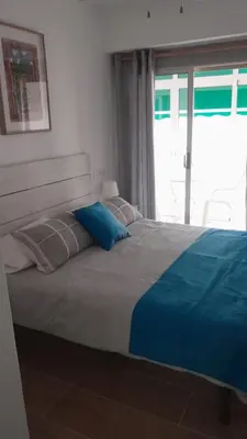 a bed with blue pillows and a window in a bedroom at 150m2 Con vistas al Mar y al Castillo de Cullera in Cullera