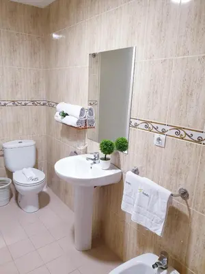 a bathroom with a sink and a toilet and a mirror at Hotel M5 Valencia Aeropuerto in Manises