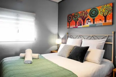 a bedroom with a bed with a painting on the wall at FLORIT FLATS - The Orange Lemon Tree House in La Eliana