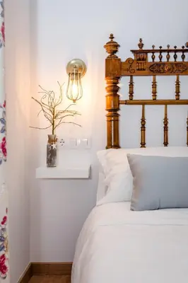 a bedroom with a bed with a wooden headboard at PALACIO Boutique in Anna
