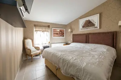 a bedroom with a large bed and a chair at Boutique House Alzira in Alzira