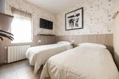 a bedroom with two beds and a tv on the wall at Boutique House Alzira in Alzira