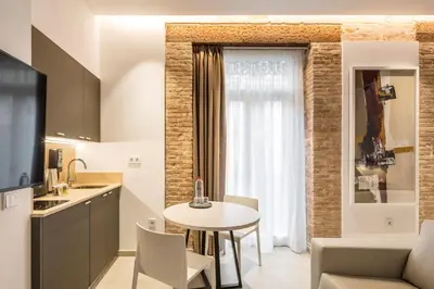 a kitchen and living room with a table and a kitchen and a dining room at Mon Suites Benlliure in Valencia