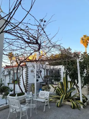 a patio with white chairs and a pergola at Casa Coqueta in Almarda