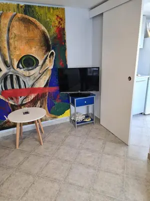 a living room with a table and a painting at Casa Coqueta in Almarda