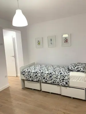 a bedroom with a bed with a blue and white comforter at UIM Mediterraneo Buenavista Wifi in Puerto de Sagunto