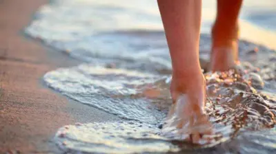 a person standing in the water on the beach at UIM Mediterraneo Buenavista Wifi in Puerto de Sagunto