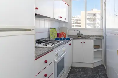 a kitchen with white cabinets and a stove top oven at El Raco, B-8-15 in Cullera