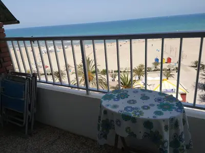 a balcony with a table and a view of the beach at 1ere soleil levant in Puerto de Sagunto