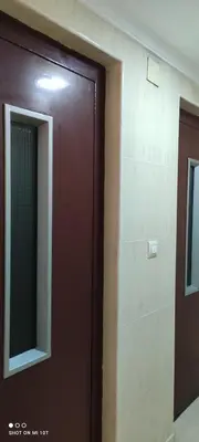 a brown door in a room with a mirror at 1ere soleil levant in Puerto de Sagunto