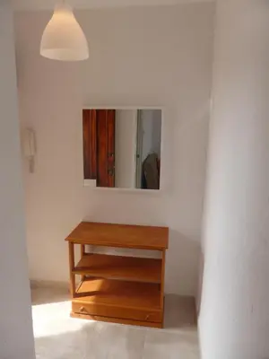 a bathroom with a wooden dresser and a mirror at Ático a 100 metros de la playa in Cullera