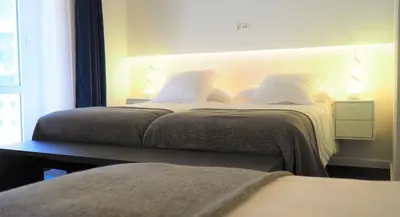 a bedroom with two beds with white pillows at PLAZA VIEW in Valencia