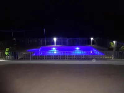 a swimming pool lit up at night with blue lights at LAS PALOMAS, appartement 2 chambres avec piscine in Turís