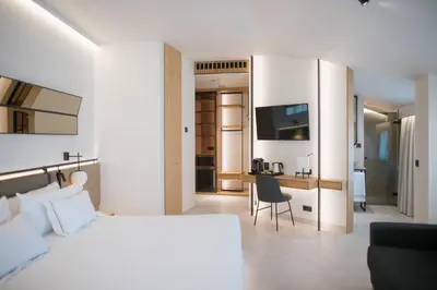 a bedroom with a large white bed and a chair at MYR Puerta Serranos in Valencia