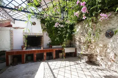 a garden with a bench and flowers on a wall at Villa Charly Casa señorial XVII Historical Villa in Macastre